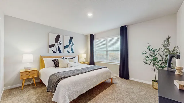 a bedroom with a large bed and a potted plant