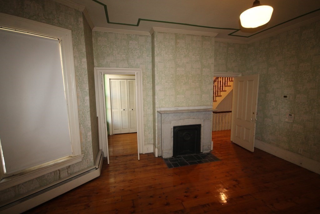 52 Mattoon Street Springfield, MA 01105 - Photo 11 of 29 a view of empty room with wooden floor and fireplace