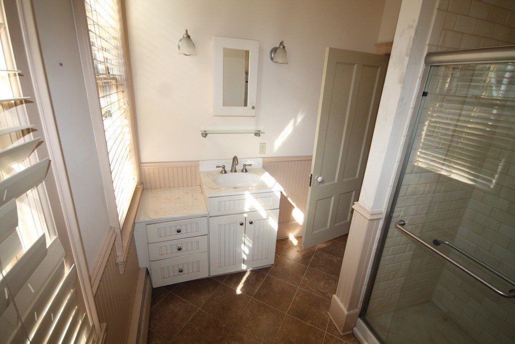 52 Mattoon Street Springfield, MA 01105 - Photo 13 of 29 a bathroom with a sink a mirror and a shower