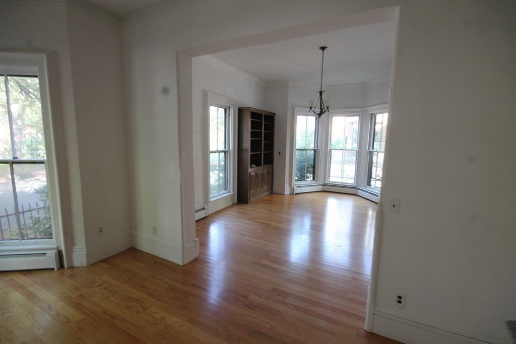 52 Mattoon Street Springfield, MA 01105 - Photo 6 of 29 a view of an empty room with window and wooden floor