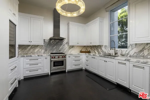 a kitchen with granite countertop white cabinets and a stove