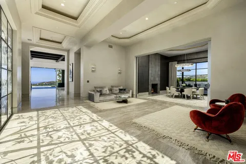 a living room with furniture a rug and kitchen view
