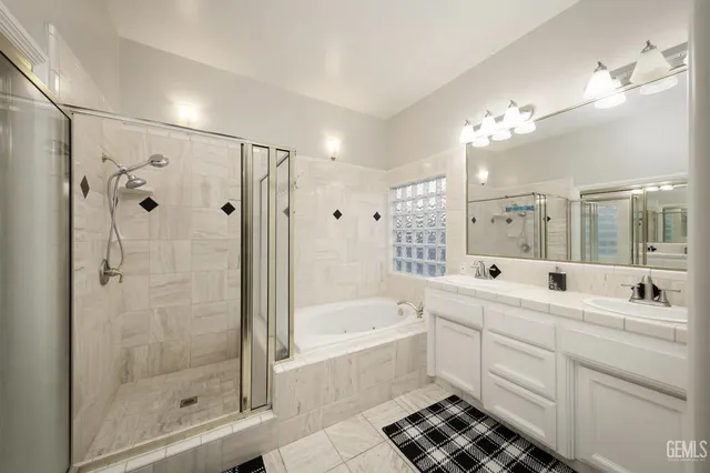 a bathroom with a double vanity sink mirror and shower