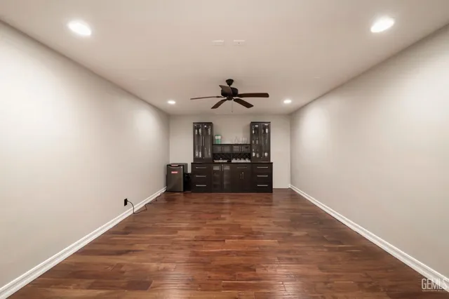 a large room with a ceiling fan and wooden floor