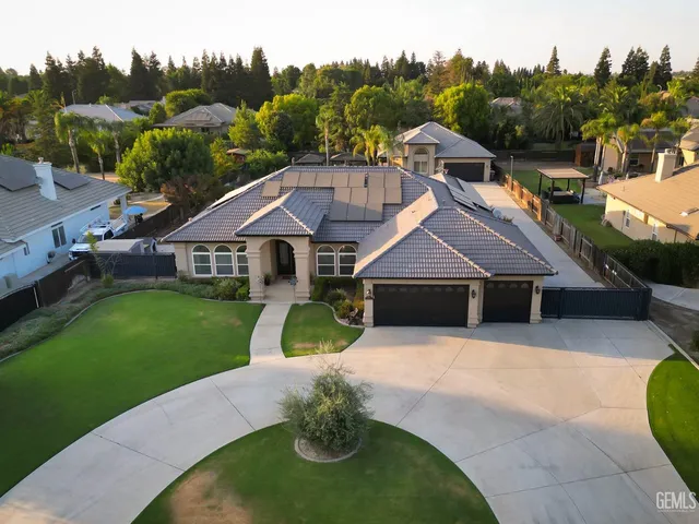 a aerial view of a house with a big yard and potted plants
