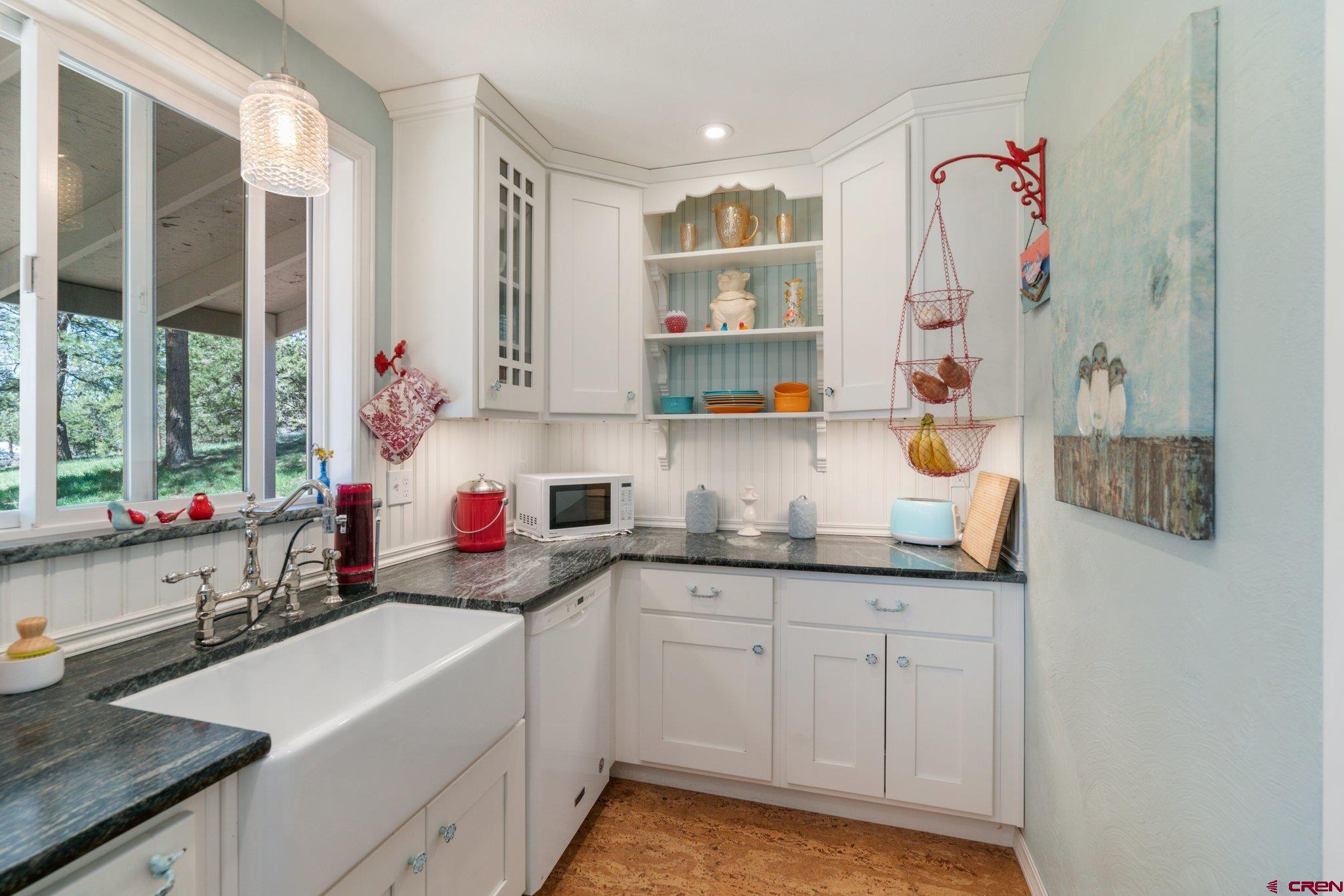 145 N Road Durango, CO 81303 - Photo 10 of 35 a kitchen with granite countertop a sink window and cabinets