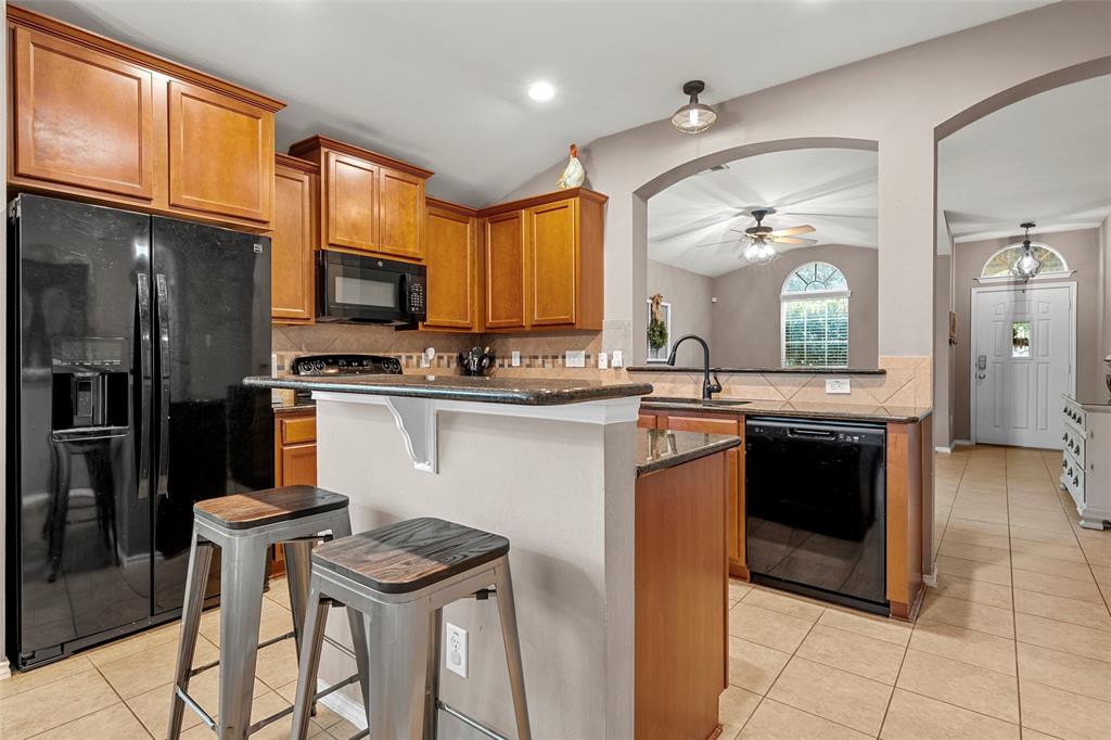6725 Cold Water Drive Waco, TX 76712 - Photo 5 of 19 a kitchen with stainless steel appliances kitchen island granite countertop a stove a sink and a refrigerator