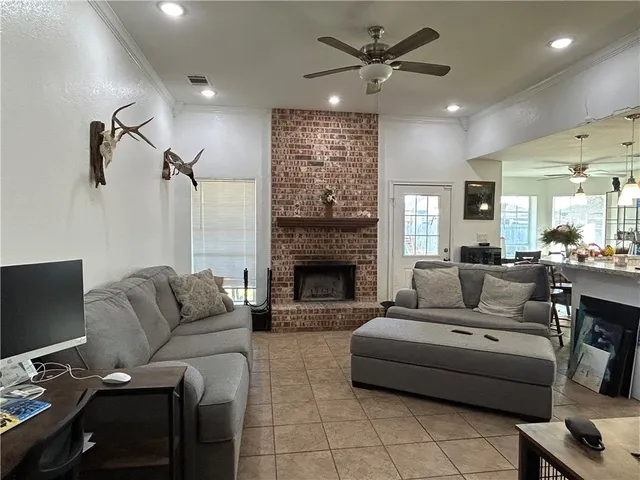 a living room with furniture a fireplace and a flat screen tv