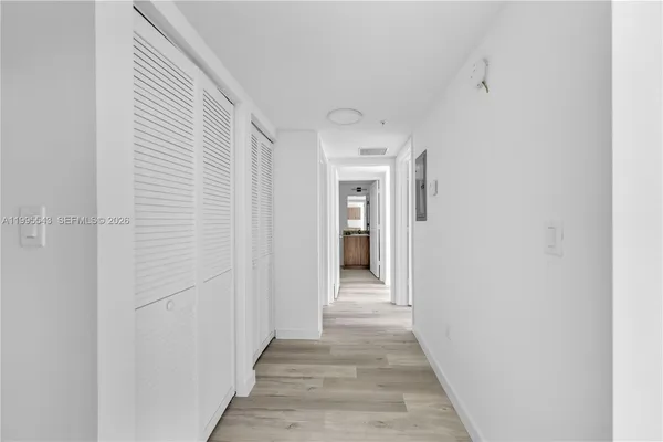a view of a hallway with wooden floor and entryway