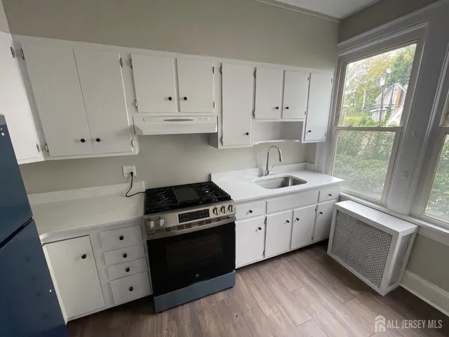 a kitchen with granite countertop white cabinets and white appliances