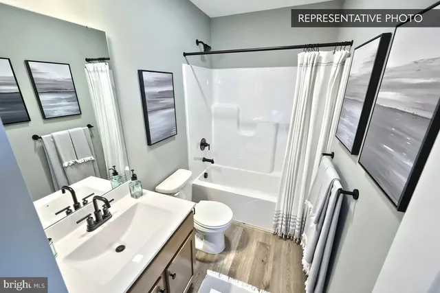 a bathroom with a sink a toilet a mirror and shower