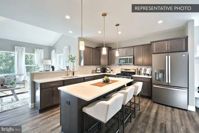 a kitchen with a sink a counter top stainless steel appliances and cabinets