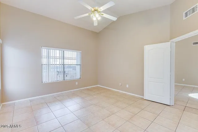an empty room with windows and fan