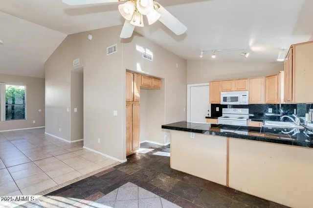 a kitchen with stainless steel appliances granite countertop a sink and a refrigerator