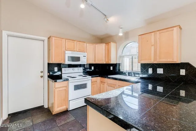 a kitchen with stainless steel appliances granite countertop a stove a sink a microwave and a refrigerator