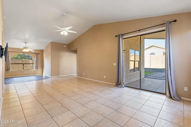 a view of an empty room with chandelier fan