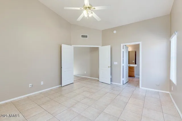 an empty room with fan and entryway