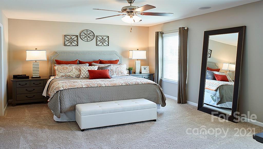 404 Misty Law Lane Clover, SC 29710 - Photo 18 of 48 a spacious bedroom with a bed and a chandelier