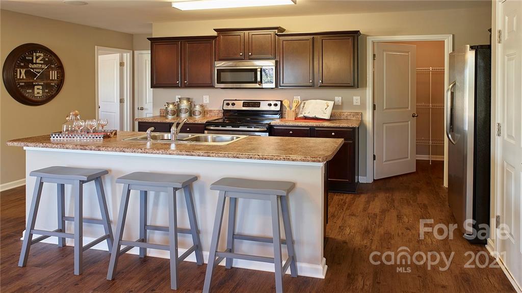 404 Misty Law Lane Clover, SC 29710 - Photo 30 of 48 a kitchen with a table chairs and a refrigerator