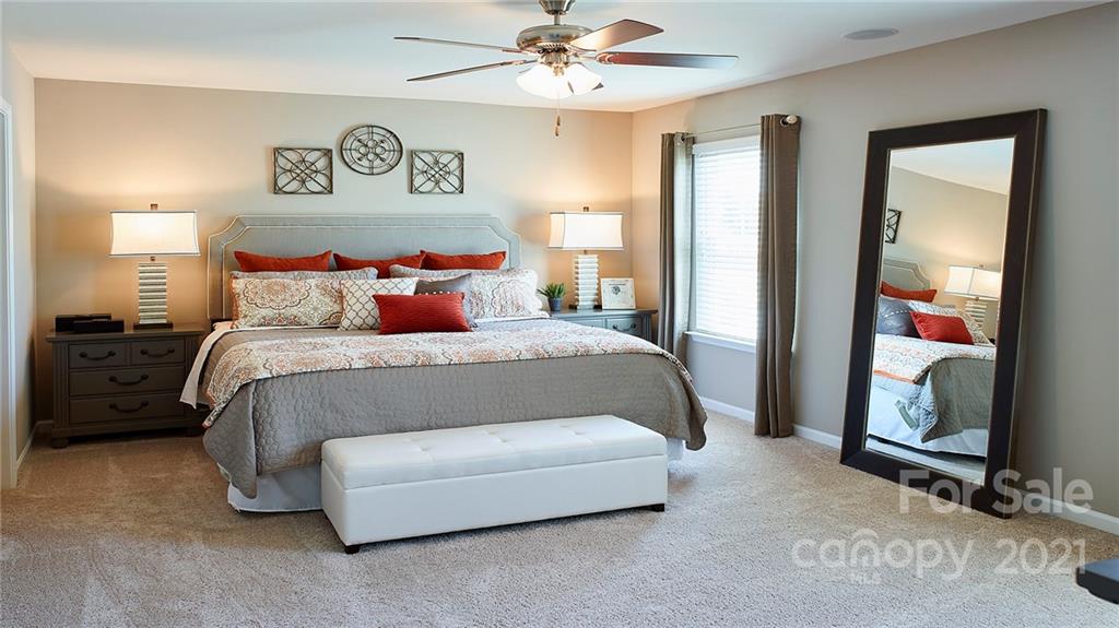 404 Misty Law Lane Clover, SC 29710 - Photo 41 of 48 a spacious bedroom with a bed and a chandelier