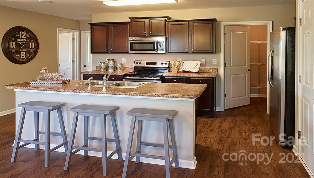 404 Misty Law Lane Clover, SC 29710 - Photo 7 of 48 a kitchen with kitchen island granite countertop wooden cabinets and stainless steel appliances