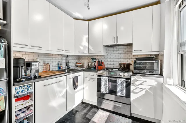 a kitchen with stainless steel appliances granite countertop a stove and white cabinets