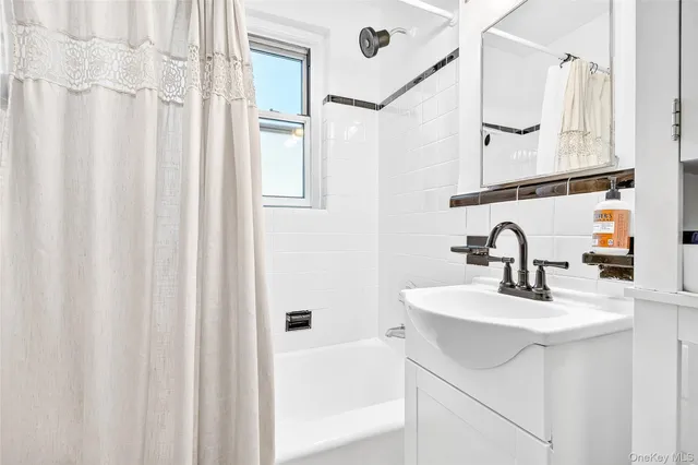 a bathroom with a sink a mirror and a shower curtain