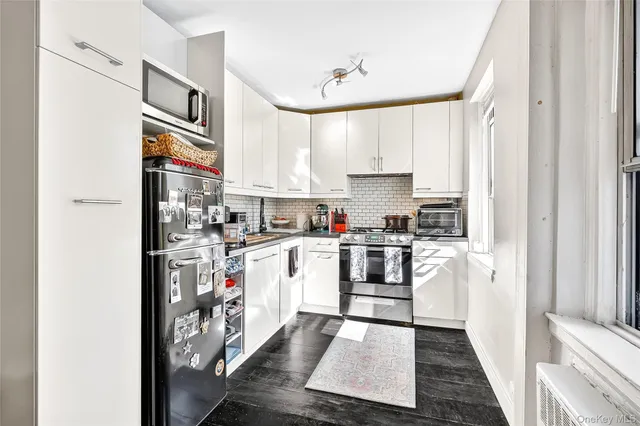 a kitchen with stainless steel appliances granite countertop a refrigerator and a stove top oven