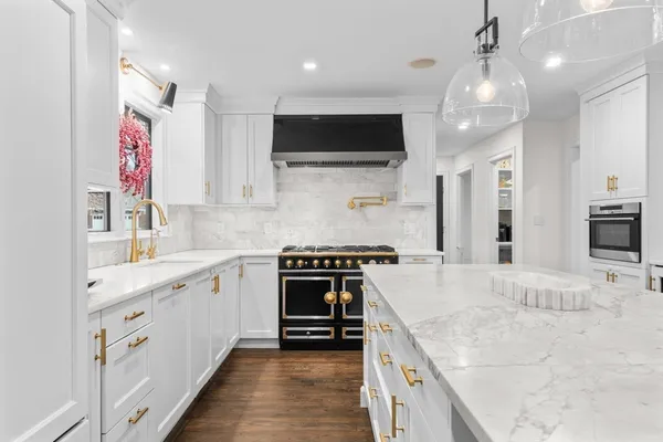 a large kitchen with stainless steel appliances granite countertop a stove and a sink