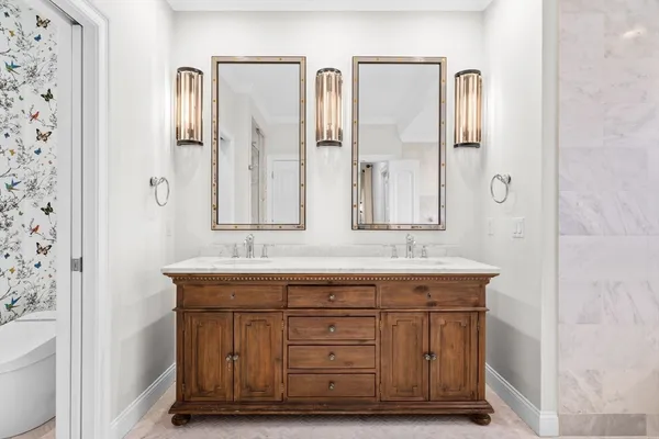 a bathroom with double sink and two mirror