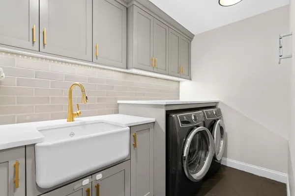 a utility room with sink dryer and washer
