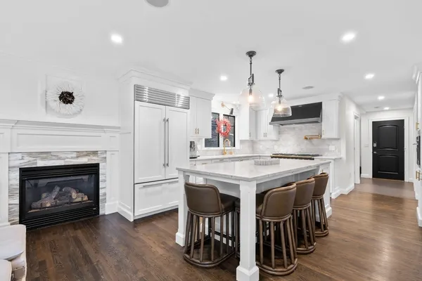 a kitchen with kitchen island granite countertop wooden floor and stainless steel appliances