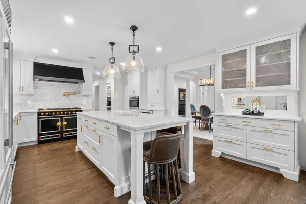a kitchen with stainless steel appliances kitchen island granite countertop a stove and a sink