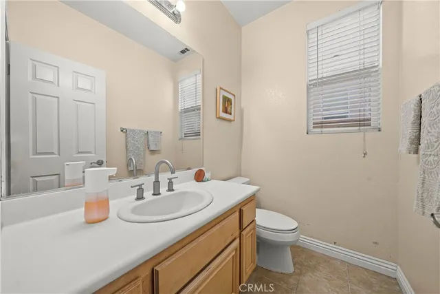 a bathroom with a granite countertop sink a toilet and a mirror