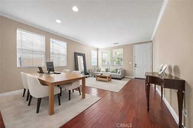 a view of a a dining room with furniture window and wooden floor