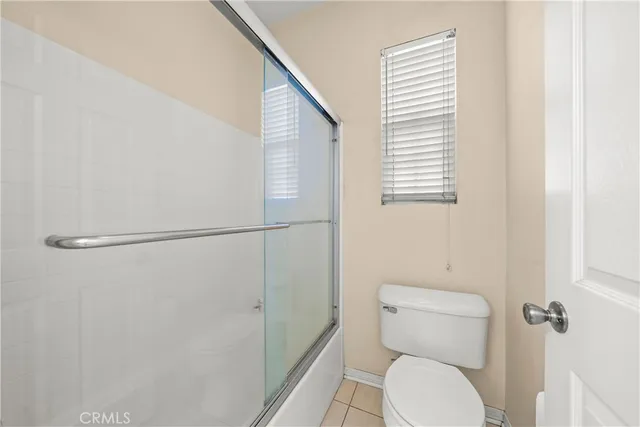 a white toilet sitting next to a shower