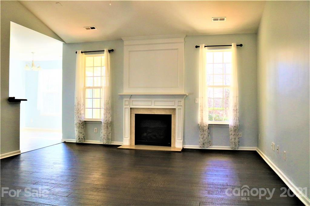 3234 Queensland Court Indian Land, SC 29707 - Photo 17 of 35 an empty room with wooden floor fireplace and windows