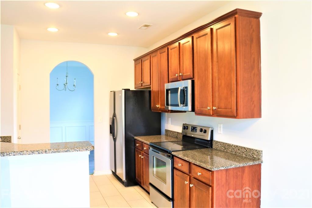3234 Queensland Court Indian Land, SC 29707 - Photo 3 of 35 a kitchen with stainless steel appliances granite countertop a refrigerator a stove a sink and a microwave