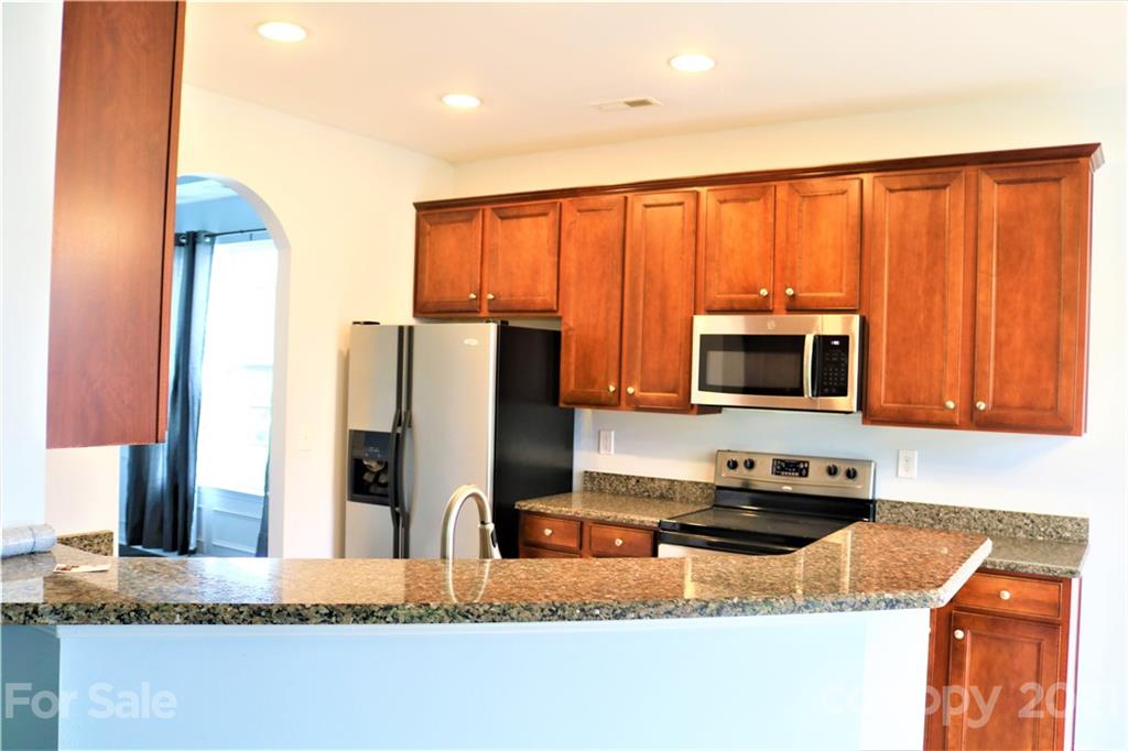 3234 Queensland Court Indian Land, SC 29707 - Photo 6 of 35 a kitchen with stainless steel appliances granite countertop a refrigerator a stove top oven a sink and dishwasher