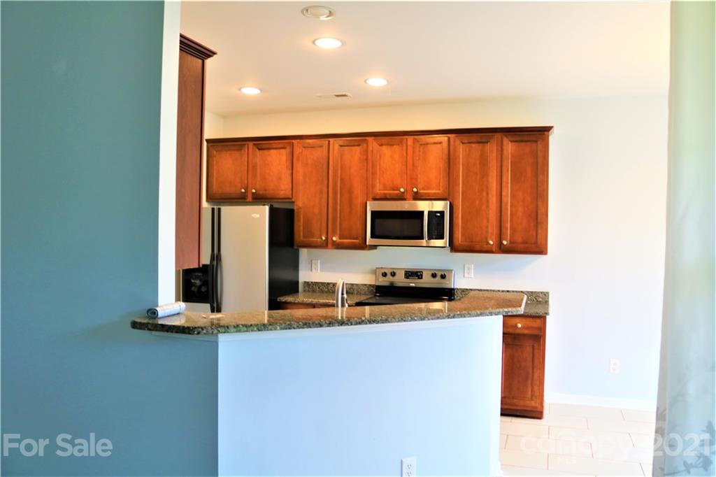 3234 Queensland Court Indian Land, SC 29707 - Photo 9 of 35 a kitchen with stainless steel appliances a microwave a sink and cabinets