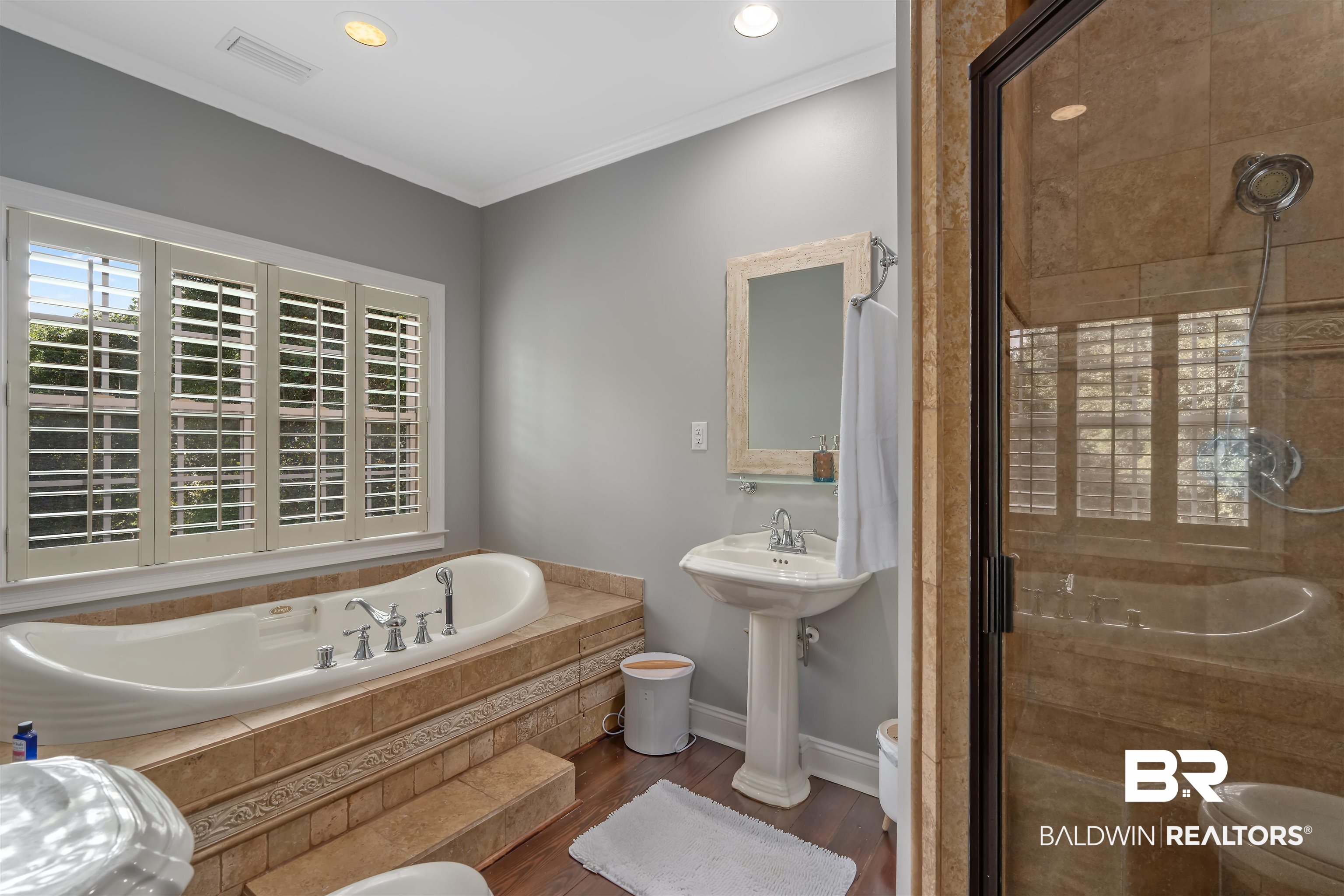 25591 Waterworld Road Robertsdale, AL 36567 - Photo 31 of 33 Bathroom featuring independent shower and bath, crown molding, hardwood / wood-style floors, and toilet