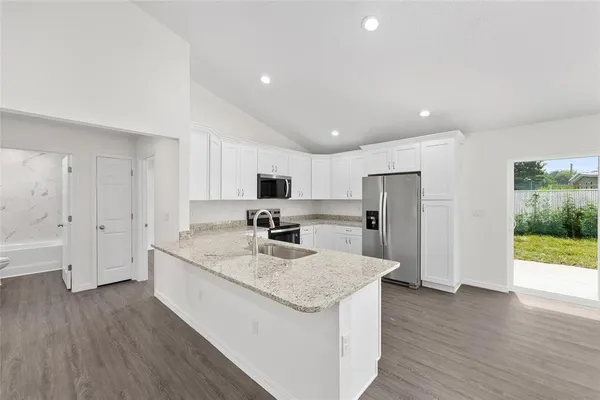 a kitchen with stainless steel appliances granite countertop a sink stove and refrigerator