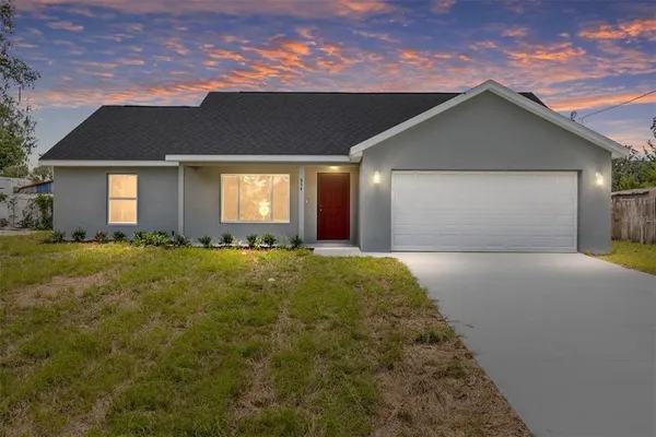 a view of a house with backyard and garden