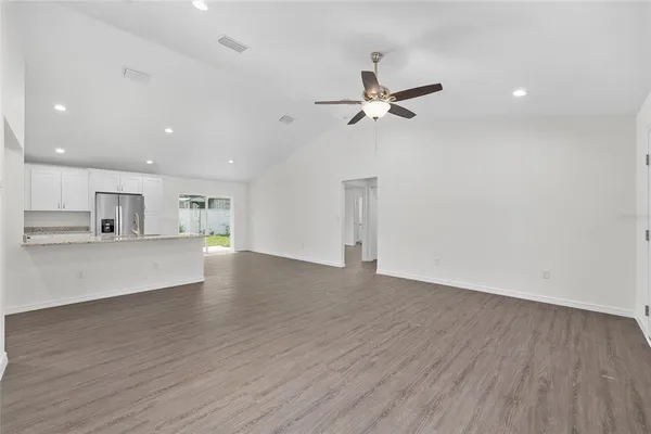 a view of empty room with wooden floor and ceiling fan