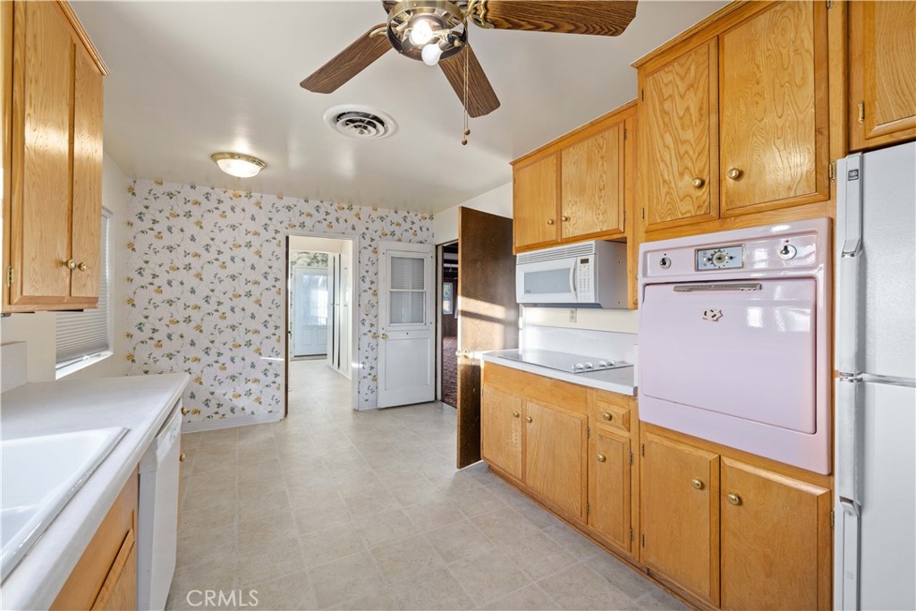 5011 East Ave R 12 Palmdale, CA 93552 - Photo 7 of 25 a kitchen with cabinets and wooden floor