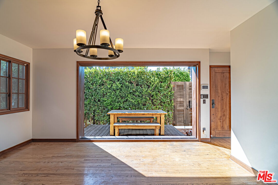 an empty room with wooden floor windows and outdoor view