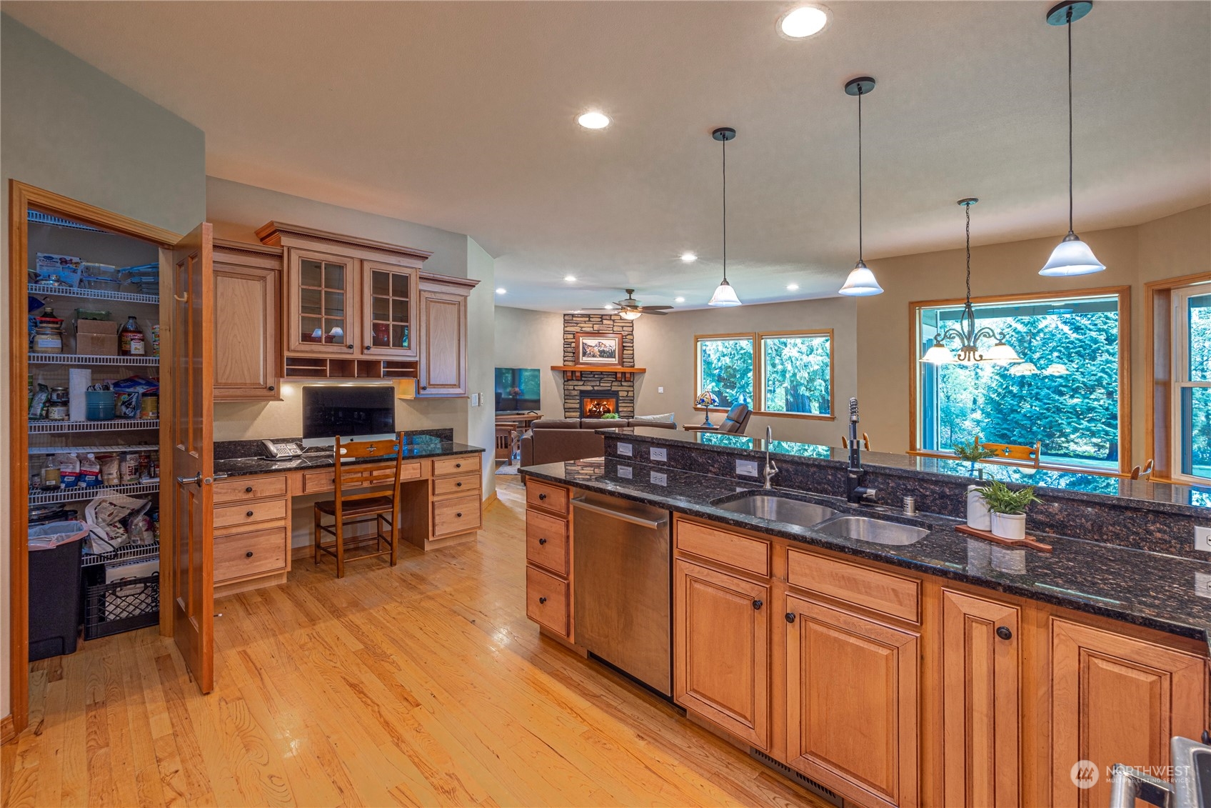 6055 East Hemmi Road Bellingham, WA 98226 - Photo 14 of 40 a kitchen with stainless steel appliances granite countertop a stove a sink dishwasher and a wooden cabinets with large window