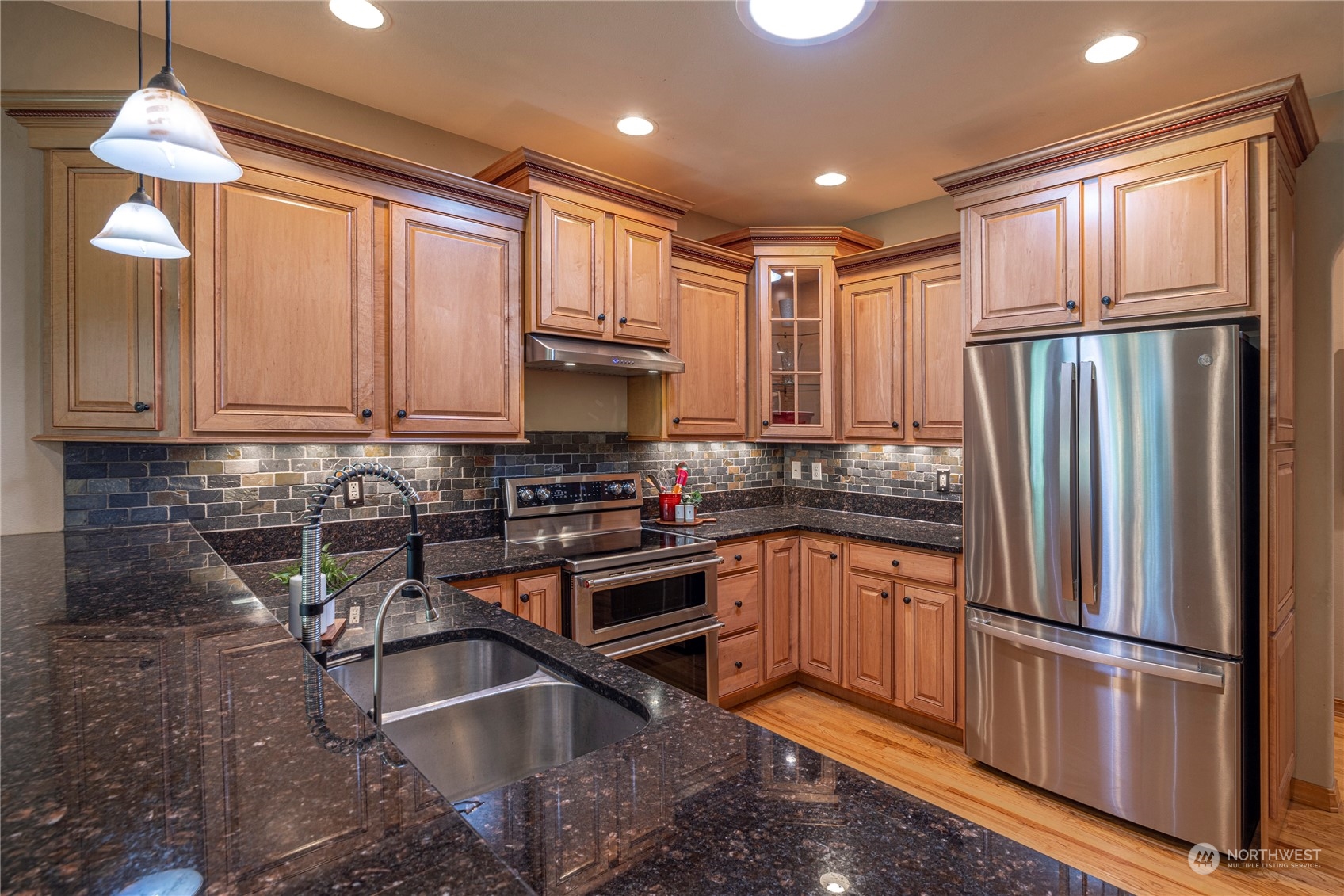 6055 East Hemmi Road Bellingham, WA 98226 - Photo 15 of 40 a kitchen with stainless steel appliances granite countertop a refrigerator sink and microwave