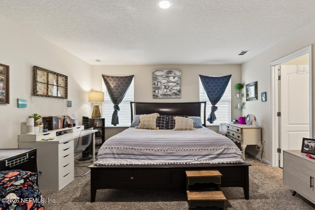 70144 Roseapple Court Yulee, FL 32097 - Photo 18 of 41 a bedroom with a bed and a kitchen in it