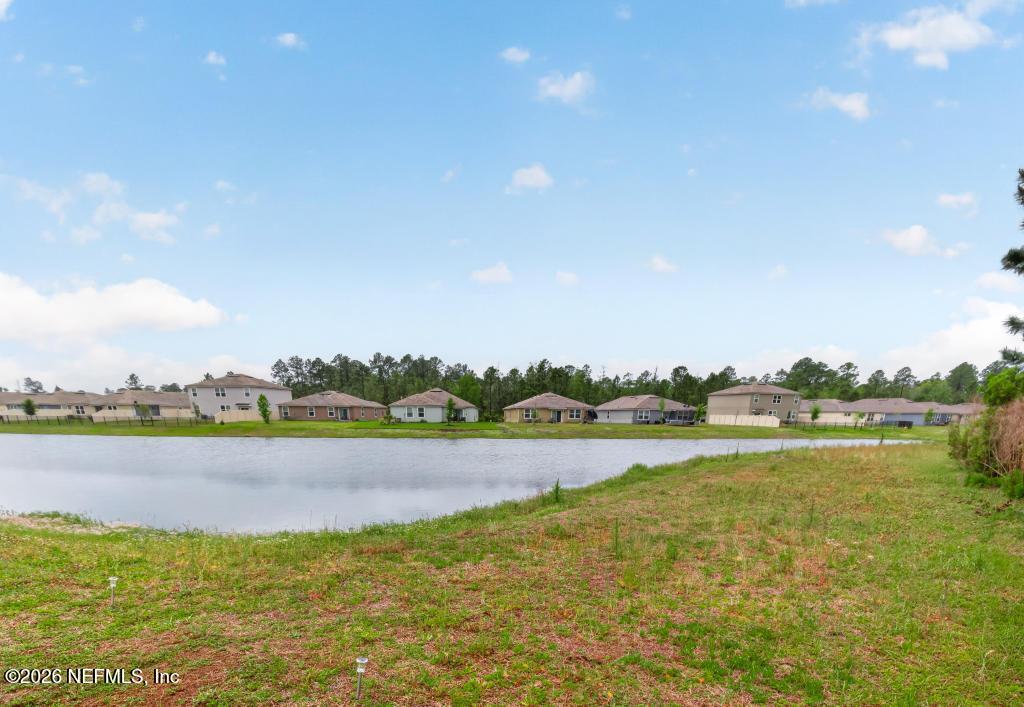 70144 Roseapple Court Yulee, FL 32097 - Photo 28 of 41 a view of a lake with houses in the back
